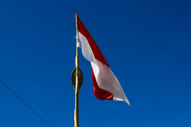 istock Indonesia flag on a bamboo pole with blue sky 1438248069