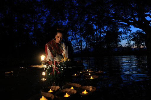 Asia woman in Thai dress traditional hold kratong and bring Krathong to float in Loi kratong day of Thailand. Loi Krathong Traditional Festival held every November to pray respect to Water Goddess