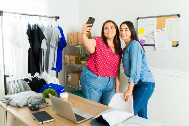 istock Cheerful friends feeling happy taking a selfie while selling t-shirts online 1438251024