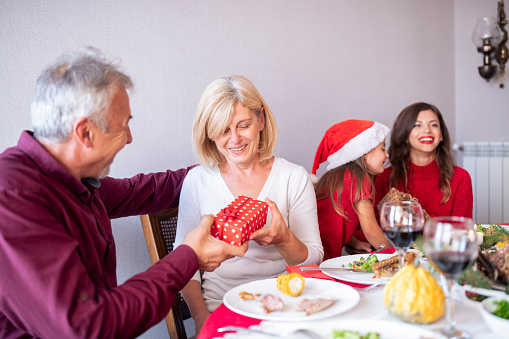 Happy family gifting Christmas presents.