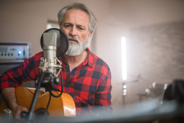 istock Senior Caucasian Guitarist Playing Classical Guitar in Recording Studio 1438260367