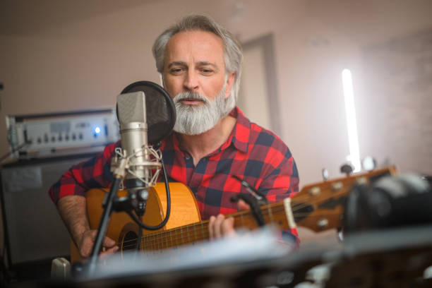 istock Senior Caucasian Guitarist Playing Classical Guitar in Recording Studio 1438260376