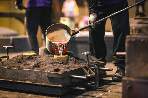 Hot Liquid Metal Being Poured Into A Mold Worker pouring molten metal into iron casts. Metallurgy factory and industrial plant. molten silver stock pictures, royalty-free photos & images