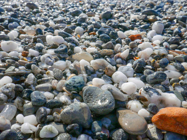 istock Mediterranean beach, sand and stones texture. Grey and black pebbles background. 1438262660