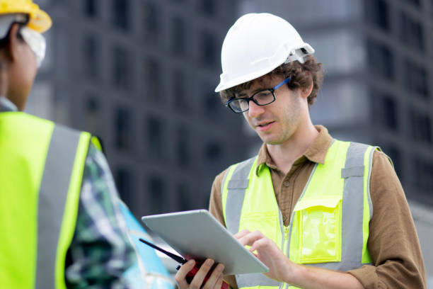 istock Young man and woman is architect planning and inspector project and looking digital tablet at construction site, engineer male and female working and examining for development real estate. 1438266214