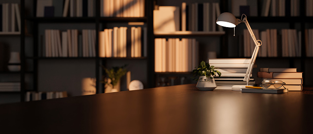 Modern dark wood tabletop with table lamp, book, decor and copy space for product display over blurred bookshelves in the background. reading room or library background. 3d render, 3d illustration