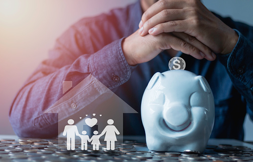Family finance plan concept, Businessman takes a position to protect the piggybank and family in hand, saving, donation, charity, fundraising, superannuation, and financial crisis concept