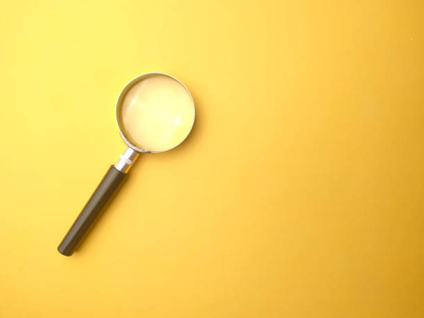 istock Magnifying glass on a yellow background with copy and text space. 1438267858