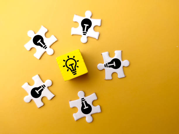istock Colored cubes and white puzzle with light bulb icons on lit and dim bulbs. 1438268645