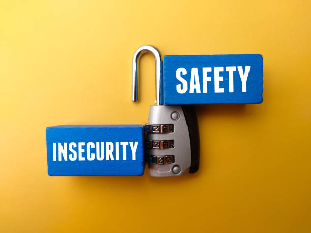 istock Colored wooden block and padlock with the word INSECURITY SAFETY. 1438268656