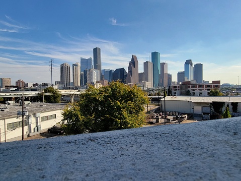 Houston downtown skyline with beautiful clouds in the background and Interstate 10 freeway and Whiteoak bayou in the foreground.