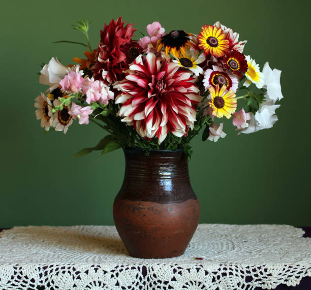 istock bouquet in a clay jug on a green background. 1438274995