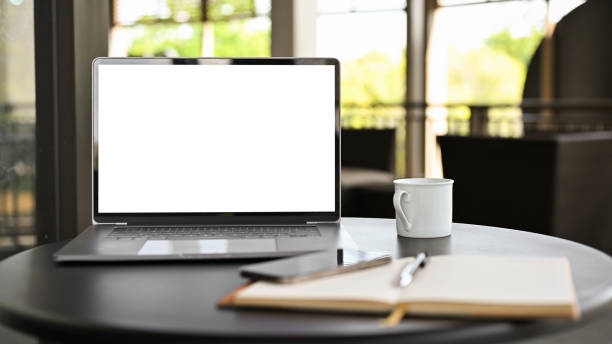 espacio de trabajo en cafetería moderna o espacio de trabajo conjunto con maqueta de pantalla blanca para computadora portátil - screen fotografías e imágenes de stock