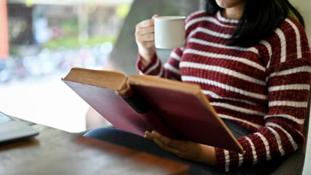 istock Bright Asian female college student concentrating on reading a book or textbook 1438277957