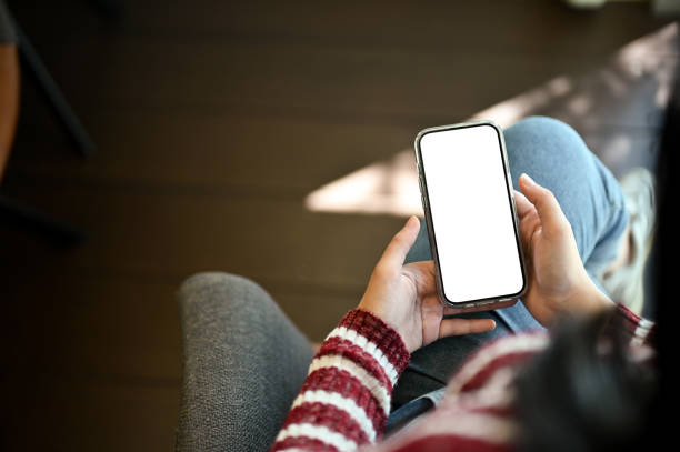 istock Above view, A woman using her smartphone while relaxes sitting on an armchair 1438278078