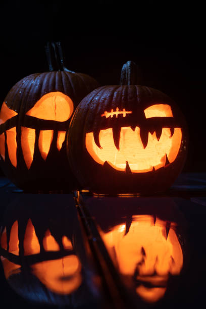 istock Twilight Jack O'Lanterns - Carved Pumpkins at Night - Scary Halloween Decorations - Close up 1438278925