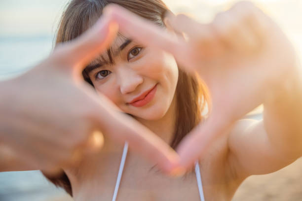 istock young woman looking through making shape camera frame made from her fingers 1438280918