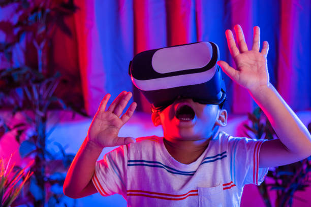 istock Asian little kid boy wearing virtual reality goggles experiencing reality 1438280927
