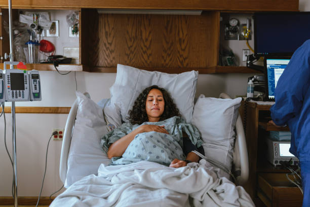Multiracial woman in hospital bed ready for labor and delivery stock photo