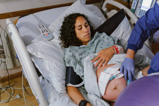 mulher grávida em leito de hospital durante o trabalho de parto - midwife human pregnancy women multi ethnic group - fotografias e filmes do acervo