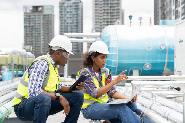 istock Group of African American engineer construction worker working in sewer pipes area at construction site. Team engineer work with laptop computer for maintenance sewer pipes, water tank 1438283616