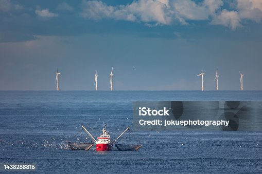 istock A cutter with lifted drag nets on the North sea with wind turbines in the background 1438288816