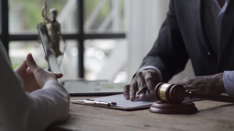 A lawyer or judge sits with a client signing important contract documents. Judicial and Legislative Legal Consultation Concept 4k Video