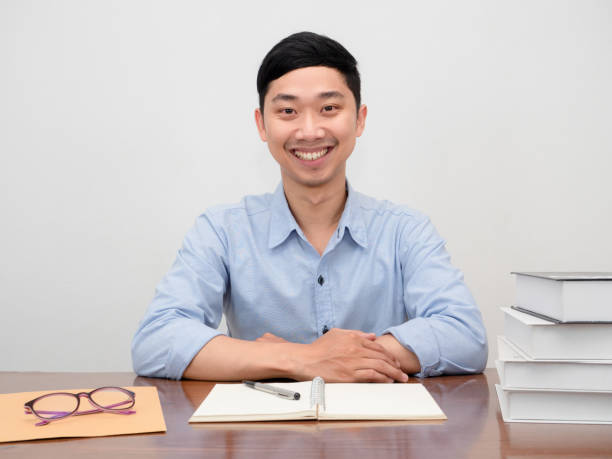 istock Positive asian businessman sit at working table happy smile 1438292927