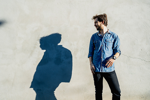 Portrait of a man with shadow on wall