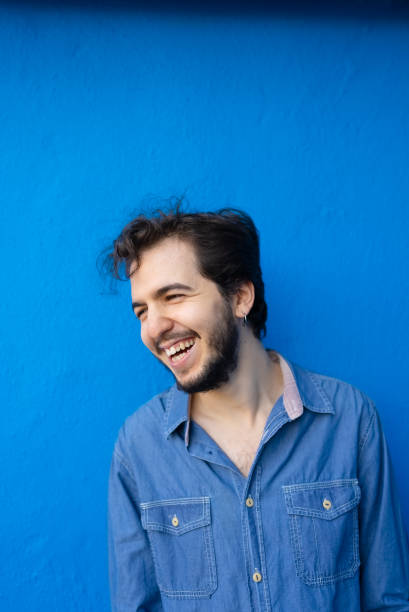 istock Portrait of a man standing blue wall background 1438294792