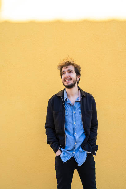 istock Portrait of a man standing yellow wall background 1438294804
