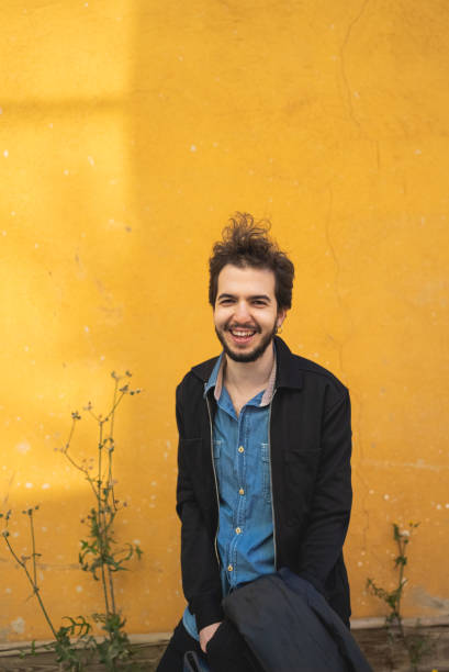 istock Portrait of a man standing yellow wall background 1438294862