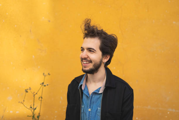 istock Portrait of a man standing yellow wall background 1438294870
