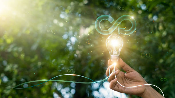 Circular economy. Hand hold light bulb with circular icon. Energy consumption and CO2 emissions, reusing and recycling existing materials for future growth of business and environment sustainable. stock photo