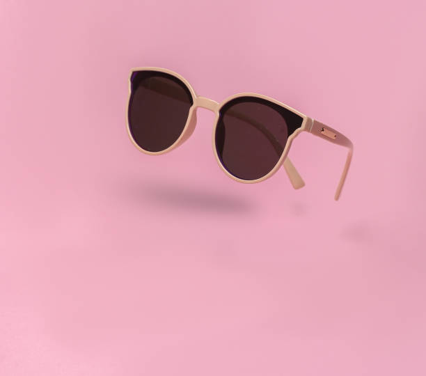 istock Soaring trendy sunglasses on pink background with shadow 1438297643
