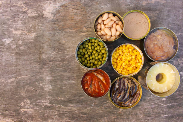 istock Different open canned food on old wooden background. Top view. Flat lay. 1438297672