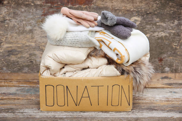 istock Donation box with winter clothes on an old wooden background. 1438297783