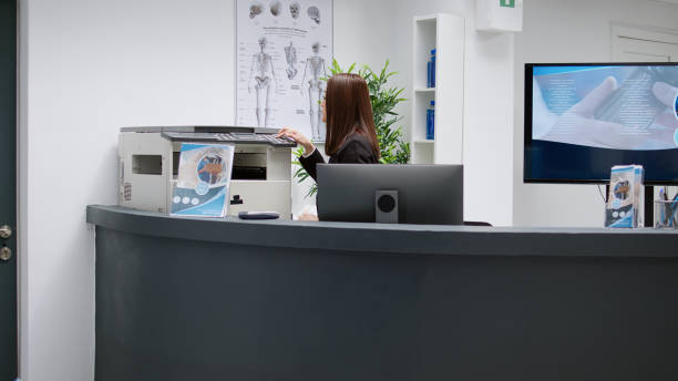 istock Female receptionist working at hospital reception desk 1438298336