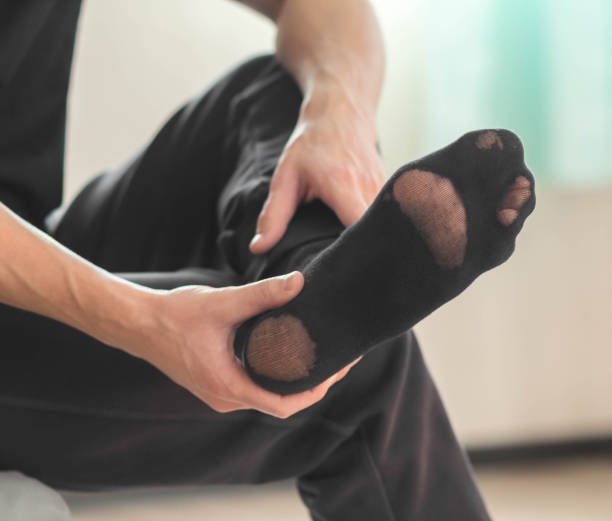 istock An old worn black sock on a man. Closeup 1438299997