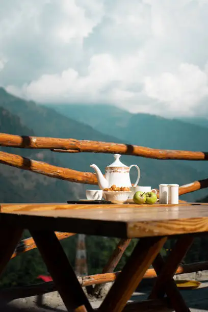 A closeup shot of tea time with snacks in white cutlery set in Manali, Himachal Pradesh