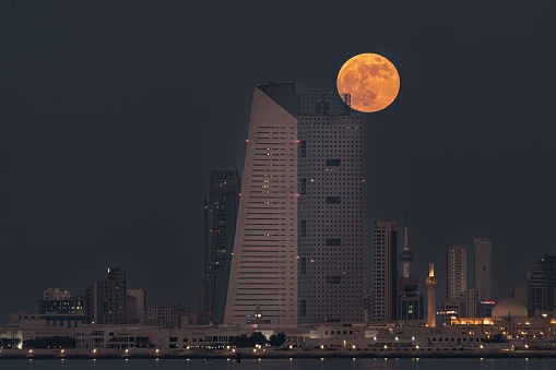 kuwait city, Kuwait – January 11, 2022: A beautiful shot of Kuwait City skyline with a full moon in Kuwait