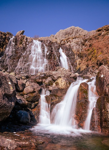 A vertical shot of waterfalls on Stickle Ghyll in the central hills of the English Lake District