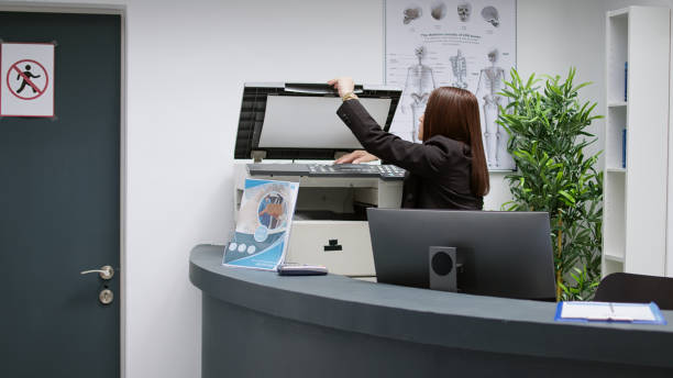 istock Asian receptionist working with medical reports at reception counter desk 1438300897