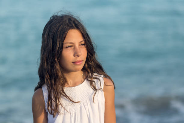 summer portrait of a little girl with wet hair in a towel, after a swim in the pool