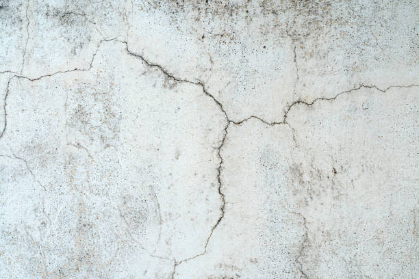 istock Old concrete stone wall covered with cracked plaster and dirty grunge textured surface. 1438301682