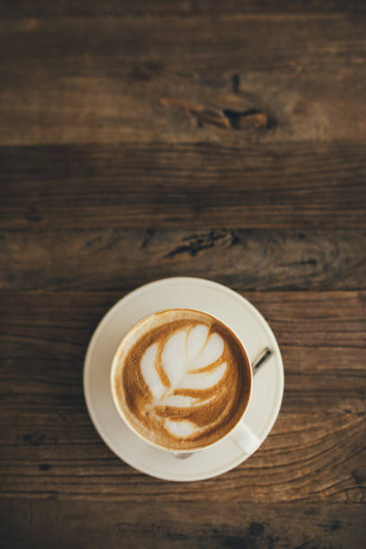 istock White cup with fresh cappuccino on wooden background 1438305399