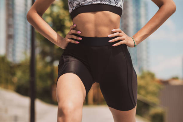 Close up of a woman exercising outdoors Exercising. Close up of a woman exercising outdoors Biker Shorts stock pictures, royalty-free photos & images
