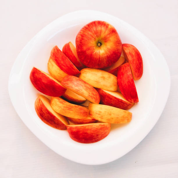 Apples fruit fresh red apple ripe juicyapples whole and sliced in a plate food sweet health beneficial nutritional value malus domestica seb apel apfel Manzana La Pomme tafaha yabloko ringo no mi, la mela, ping guo, hi-res closeup view image stock photo manzanas fruta fresca manzana roja madura jugosas enteras y cortadas en rodajas en un plato alimento dulce salud beneficioso y nutritivo malus domestica seb apel apfel manzana la pomme tafaha yabloko ringo no mi, la mela, ping guo, hi-res primer plano ver