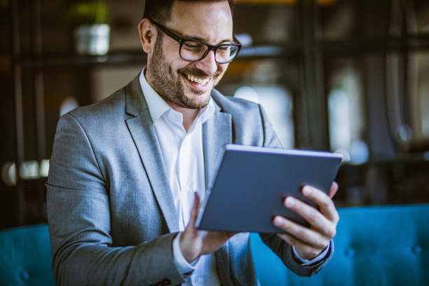 istock Happy businessman working on digital tablet in the office. 1438309015