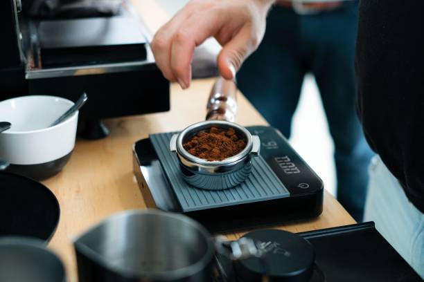 istock Human hand measuring freshly grounded coffee on scale before putting into machine 1438310019